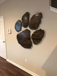 the wall is made out of wood and has four pieces of art hanging on it