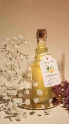 a bottle of essential oil next to some flowers