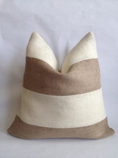 a brown and white striped pillow sitting on top of a bed