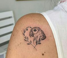 a woman with a tattoo on her shoulder has an owl and flower in the shape of a heart