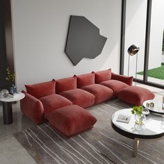 a modern living room with red couches and tables