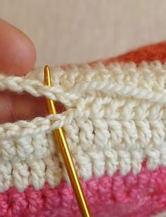 the crochet stitch is being worked on by a person with a knitting needle