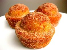 three sugared muffins sitting on top of a white plate next to each other