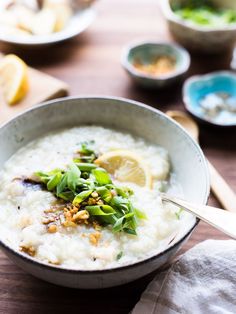 a bowl filled with oatmeal and topped with lemon wedges on a wooden table