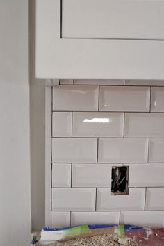 a kitchen with white tile on the backsplash and counter tops that have been removed