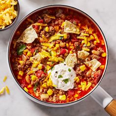 a pot filled with chili, corn and cheese