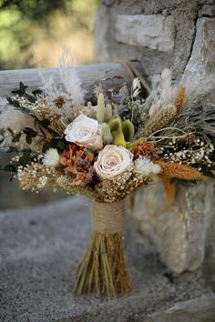 a bouquet of flowers sitting on top of a stone wall