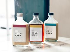 three bottles of cold brew sitting on top of a counter