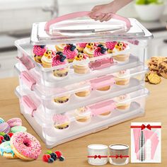 a plastic container filled with lots of cupcakes on top of a wooden table