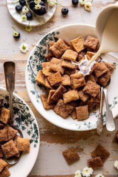 two bowls filled with croutons and blueberries on top of a wooden table