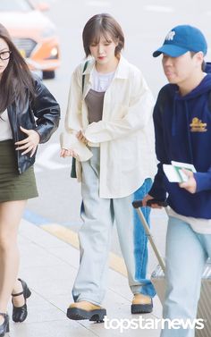 two young people are walking down the street