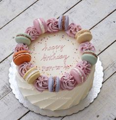 a birthday cake decorated with macaroons and frosting