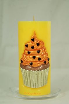 a yellow candle with a cupcake on it