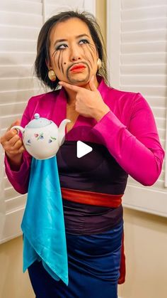 a woman is holding a teapot with her face painted