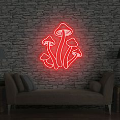 a red neon sign that is on the side of a brick wall next to a couch