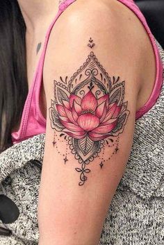 a woman's arm with a pink lotus tattoo on the back of her shoulder