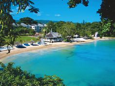 an aerial view of a beach and resort with clear blue water in the foreground