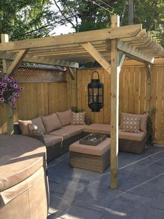 an outdoor living area with couches, table and gazebo in the back yard