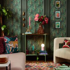 a living room with green wallpaper and pink couches in front of a coffee table