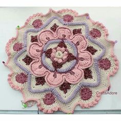 a crocheted doily with pink and purple flowers