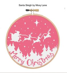 a cross stitch christmas ornament with santa claus on his sleigh flying through the sky