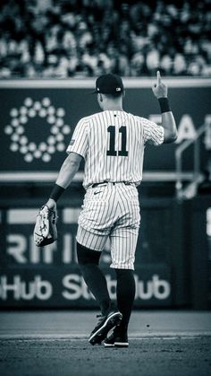 a baseball player is walking on the field with his glove in hand and one hand up