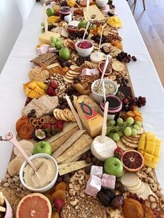 a long table covered in lots of different types of cheeses and crackers on it