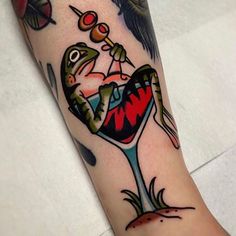 a tattoo on the arm of a person with a wine glass and two birds in it