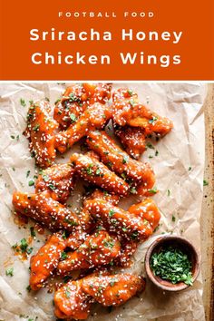 chicken wings covered in sesame seeds and garnished with parsley on parchment paper