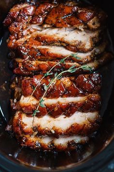 sliced pork in a slow cooker with herbs