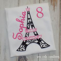 the eiffel tower is embroidered on a white t - shirt with pink trim