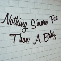 writing on the side of a white brick wall that says nothing s'more fun than a baby