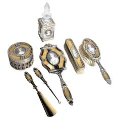 This antique ladies dresser set has no maker's marks but presumed to have been made in approximately 1900 in the 'Louis XVI' style. This seven piece set includes two brushes, a handled mirror, a dresser box, a scent or perfume bottle, and a shoe horn and lace hook. Each piece is done with a gilt finished bronze 'frame' which has been inlaid with enameled glass done in a gold color with a quite well executed hand painted miniature portrait. The dresser box has pierced sides with a glass insert an Item References, Antique Decorating, Cozy Minimalism, Antique Vanity Set, Hand Mirrors, Painted Portraits, Vanity Sets, Dresser Set, Vintage Dressing Tables