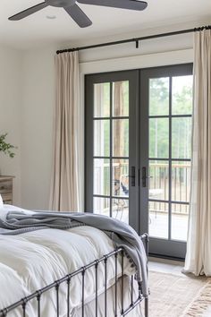 a bedroom with a bed, ceiling fan and sliding glass doors