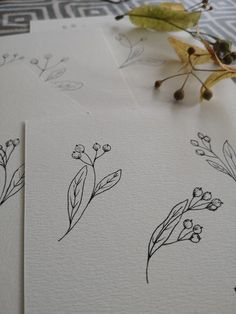 some flowers are drawn on white paper and placed next to each other