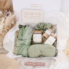 a gift box filled with lots of goodies on top of a white tablecloth