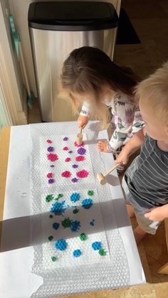 two children are playing with an art project