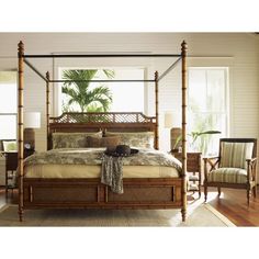 a bedroom with a bed, chair and table in front of a large window that has palm trees on it