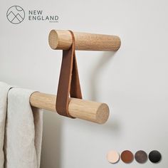 a wooden coat rack hanging on the wall next to a white towel and other items