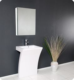 a white sink sitting next to a mirror on a wall in a room with grey walls