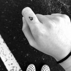 a person's hand with a small triangle tattoo on it