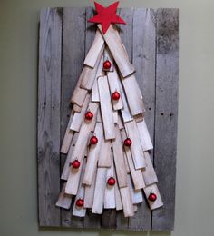 a christmas tree made out of popsicle sticks is displayed on a wooden plank wall