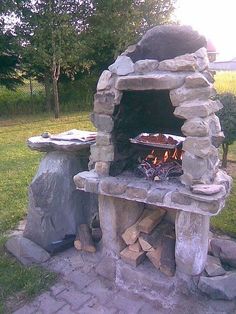 an outdoor stone oven sitting on top of a brick patio next to a fire pit