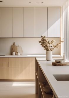 a vase with flowers sitting on top of a kitchen counter