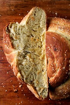 two loaves of bread sitting on top of a wooden cutting board