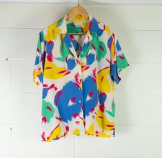 Stunning Women's Silk Blouse | Summer Colours | Oversized | Great Condition Description Super fun statement piece for Summer. Pops of classic 80s colour and 100% silk! Great oversized blouse with button up front. Bottom button is missing but you won't miss this if it's tucked in! Some small markings as pictured.   Material - Silk Brand - Harold Grant Collection Size -  "M"  Measurements lying flat Waist - 56cm Bust - 57cm  Length - 68cm  Sleeve Length - 22cm  Model usually wears size 6-8 and mea Retro Multicolor Relaxed Fit Blouse, Retro Relaxed Fit Multicolor Blouse, Retro Multicolor Silk Tops, Summer Colours, Blouse Summer, Oversized Blouse, Summer Colors, Silk Blouse, Womens Clothing Tops