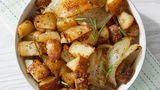 a white bowl filled with potatoes on top of a table