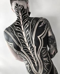 a man with black and white tattoos on his body