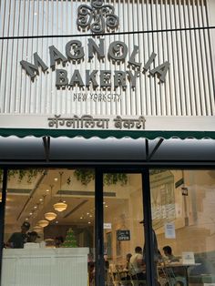 the front entrance to a bakery with people walking by