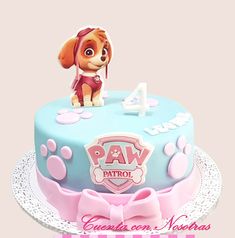 a birthday cake for a girl with paw patrol on top and pink bows around the edges